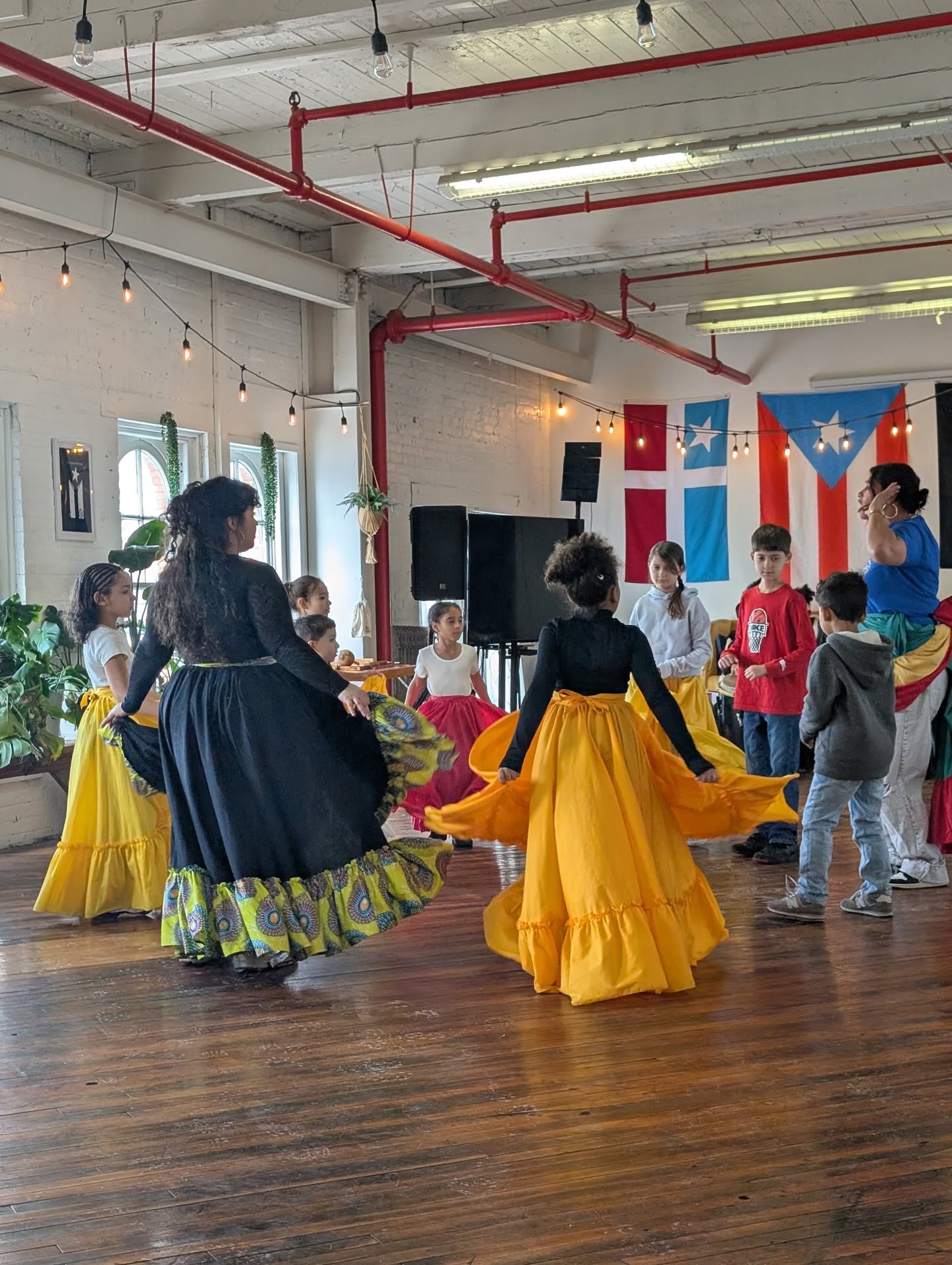 Bembé Baile class — teens and young adults dancing in traditional Bomba skirts / Clase de Bembé Baile — adolescentes y jóvenes bailando con faldas tradicionales de Bomba