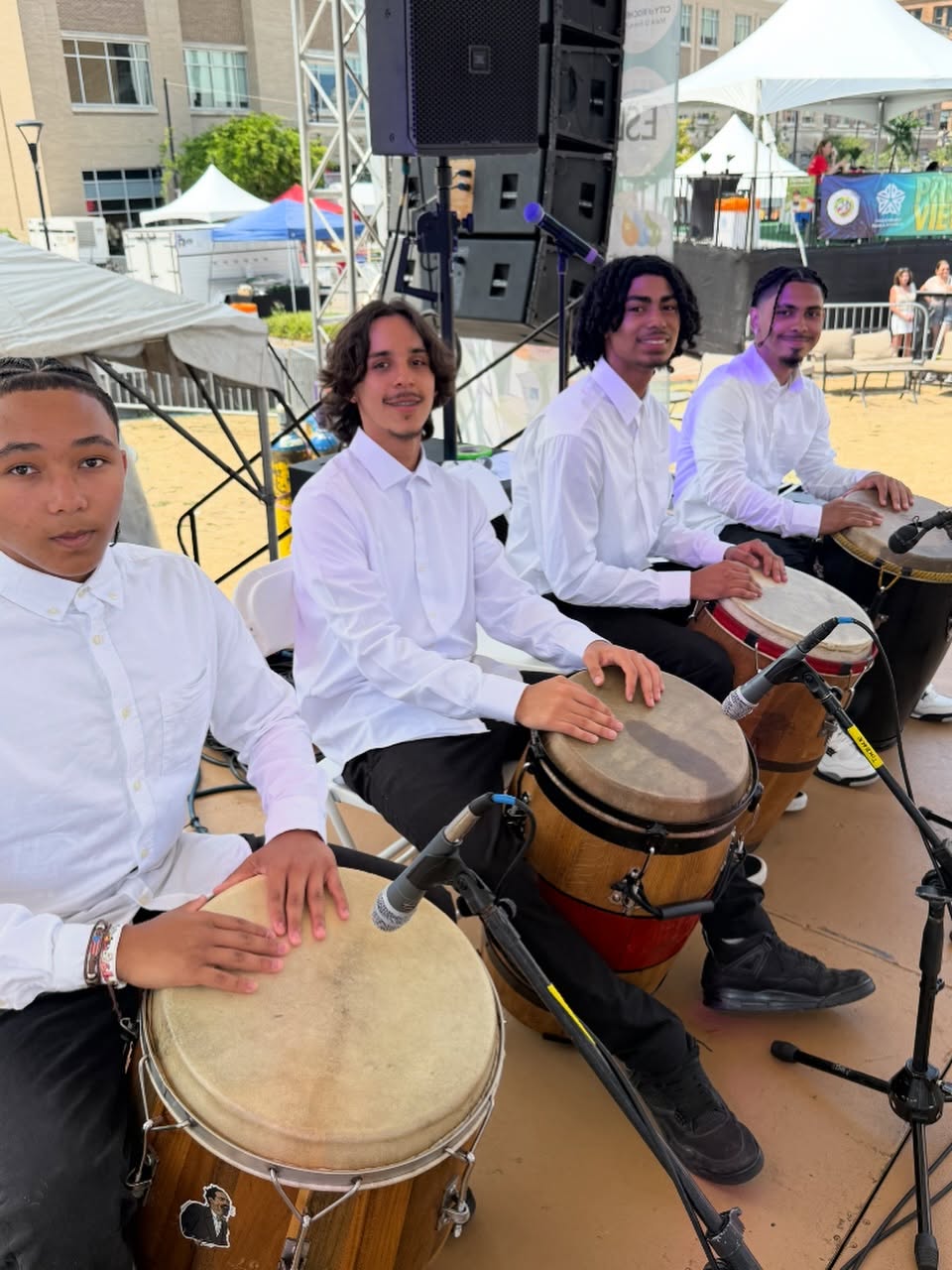 Bembé Buleo class — teens drumming together in a rehearsal circle / Clase de Bembé Buleo — adolescentes tocando tambores juntos en círculo de ensayo